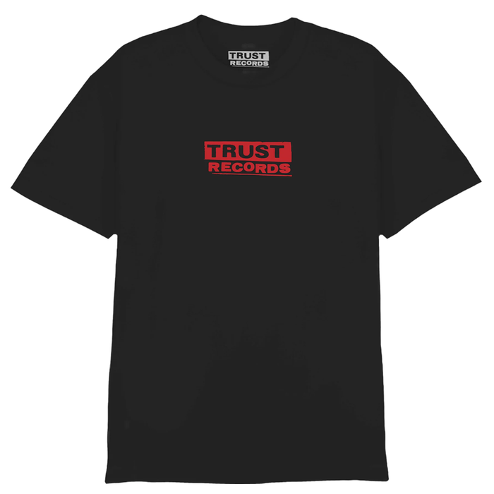 A black T-shirt by Ink & Dagger, crafted from soft Comfort Colors fabric, featuring a small red rectangle on the chest with TRUST RECORDS printed in white and black lettering. The MAGPrinted logo is also located inside the collar tag, making this a standout piece among lettering shirts.